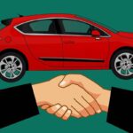 Illustration of a handshake in front of a red car, symbolizing a car rental agreement.