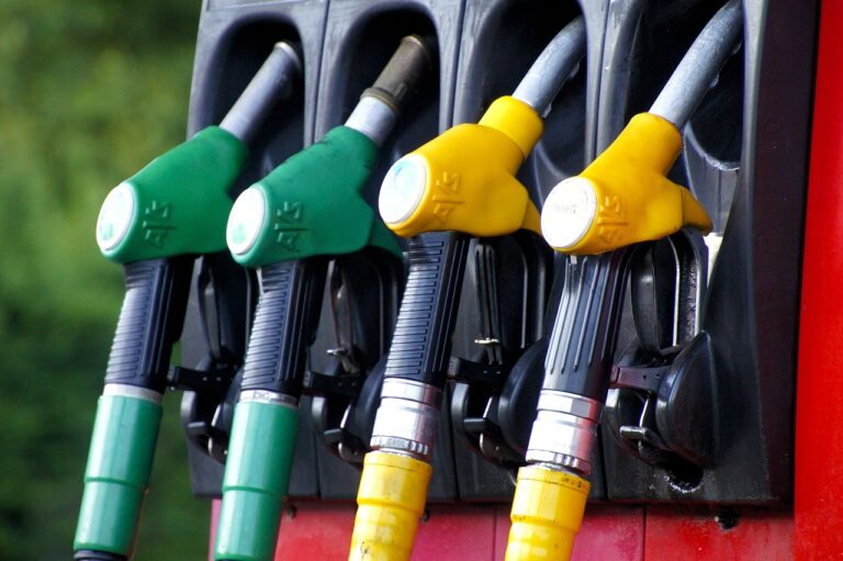 Close-up of gas pump nozzles with green and yellow handles.